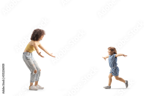 Full length profile shot of a little girl runnuning towards a young female with curly afro hairstyle