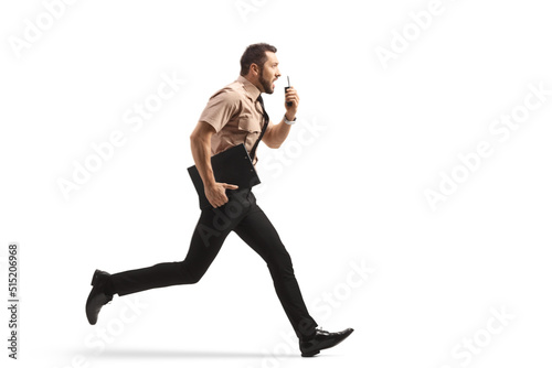 Full length profile shot of a security guard running and using a walkie talkie