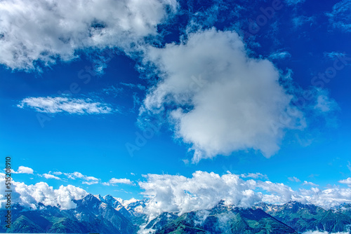 textured clouds in a azur blue sky over some snowy summits of the Austrian Alps 