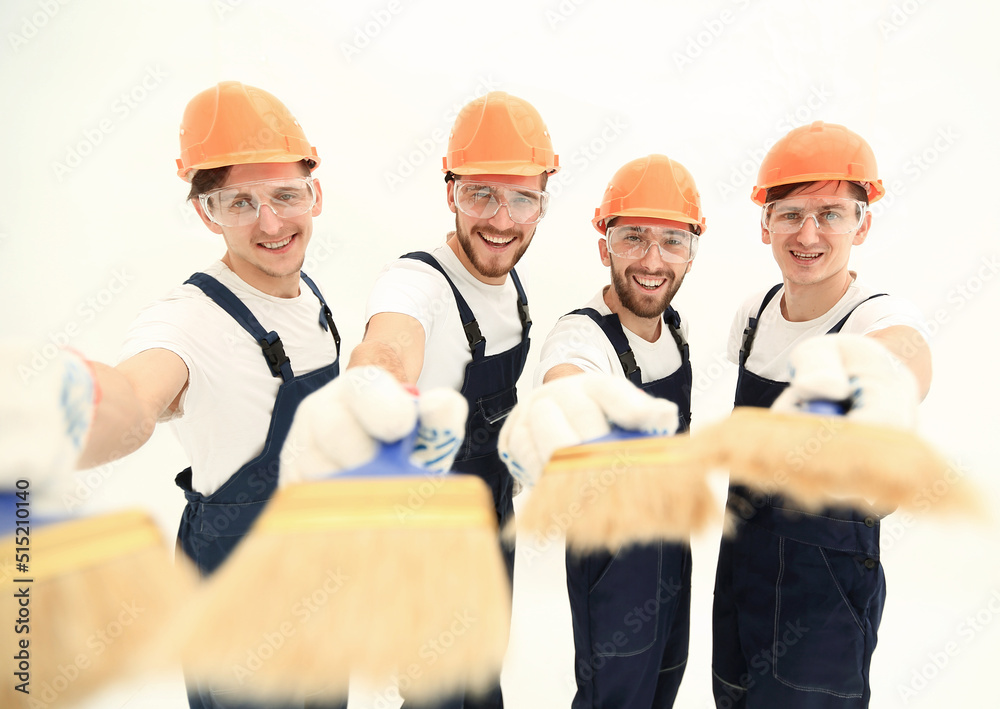smiling group of builders with a paint brush smiling group of builders with a paint brush
