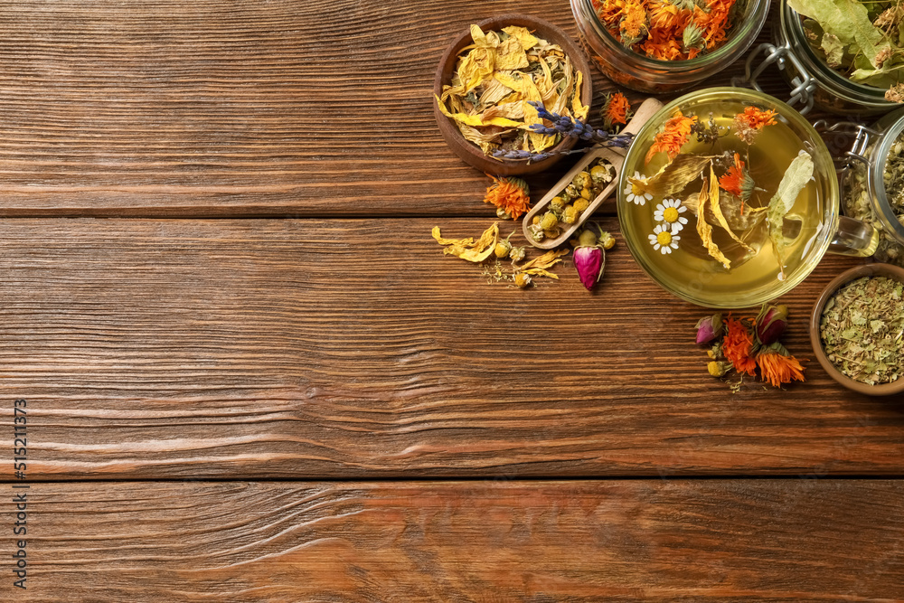 Freshly brewed tea and dried herbs on wooden table, flat lay. Space for text Freshly brewed tea and dried herbs on wooden table, flat lay. Space for text