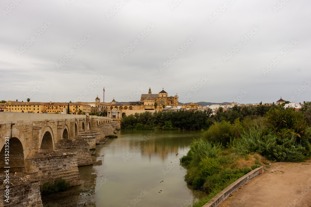 Cordoba, Spain, September 13, 2021: Guadalquivir River and the Roman Bridge, with Cordoba Mosque-Cathedral in the background.