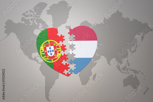 puzzle heart with the national flag of portugal and luxembourg on a world map background.Concept.