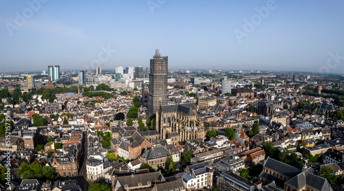 Aerial of the medieval Dutch city centre of Utrecht with cathedral towering over the city in scaffolding during sunny day. Cityscape urban area in The Netherlands