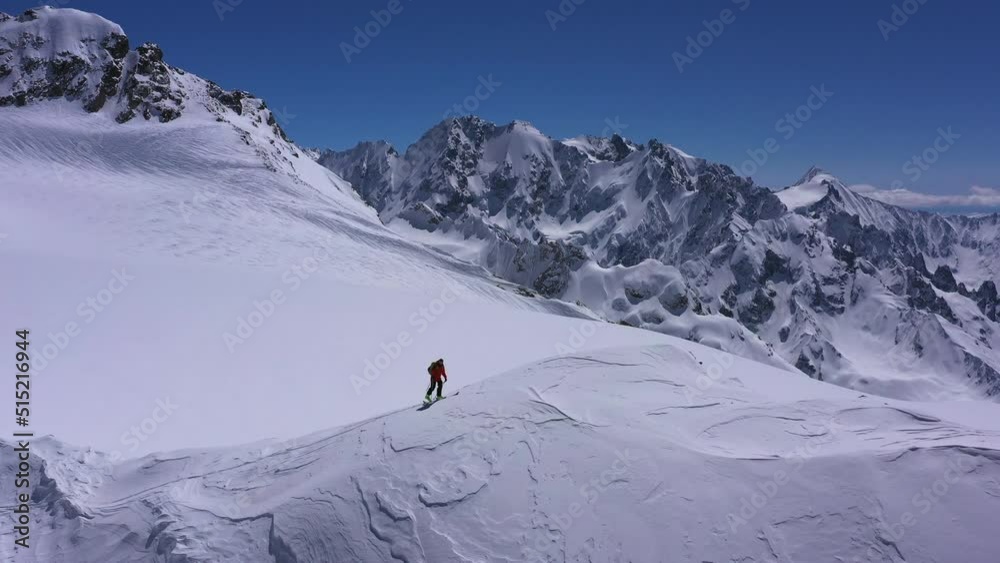 Climber in a red siut walking Up Mountain Expedition Aerial Flight Epic Mountain Range Climb To Success Beautiful Peak Winter Vacation Exploration Adventure Hiking Tourism Concept. Climber in a red siut walking Up Mountain Expedition Aerial Flight Epic Mountain Range Climb To Success Beautiful Peak Winter Vacation Exploration Adventure Hiking Tourism Concept.