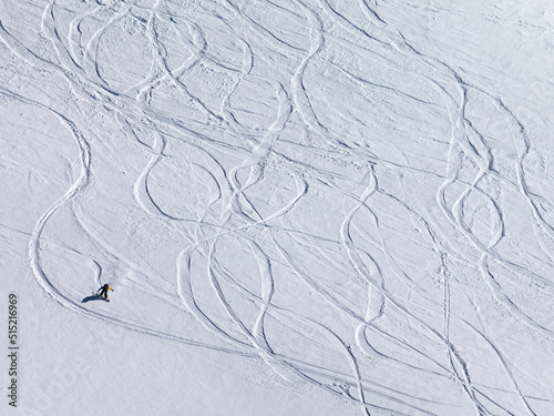 Snowboarder downhill on off piste slope with newly-fallen snow