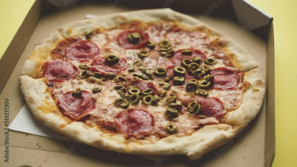 Pizza in a cardboard box, yellow background Pizza in a cardboard box, yellow background