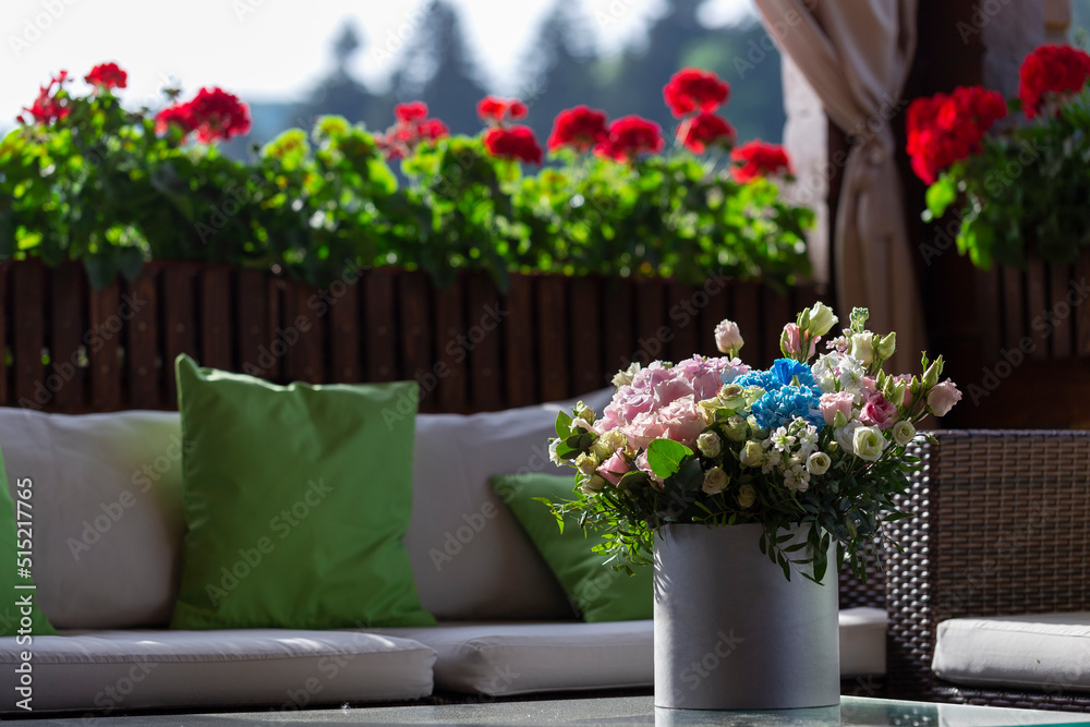 A rose bouquet in a box on a summer terrace. A bouquet of pink and white roses decorated in a hat box created by a florist. A rose bouquet in a box on a summer terrace. A bouquet of pink and white roses decorated in a hat box created by a florist.