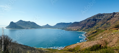 Wide angle panorama of mountain coastline against clear blue sky in South Africa. Scenic landscape of Twelve Apostles mountain range near a calm ocean in Hout Bay. Popular hiking location from above photo