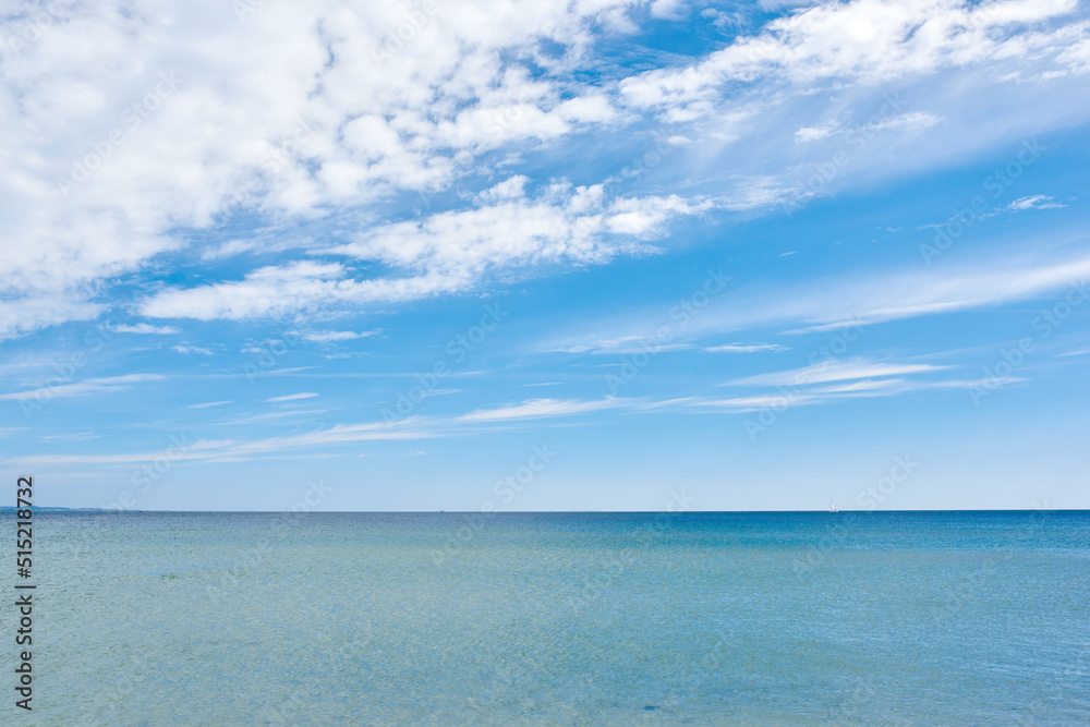 Copy space at sea with a cloudy blue sky background. Calm water surface across an empty ocean across the horizon. Scenic and tranquil seascape panorama view for a peaceful summer getaway in nature