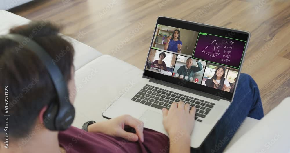 Asian teenage boy using laptop for video call, with male teacher and class on screen