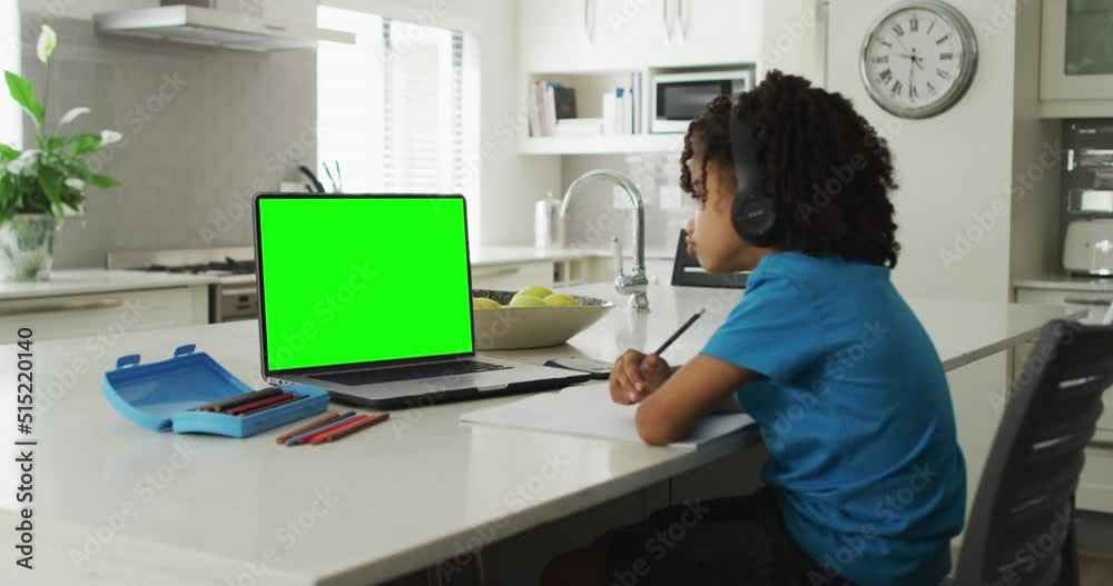 Animation of biracial boy in headphones having online lessons on laptop with copy space home Animation of biracial boy in headphones having online lessons on laptop with copy space home