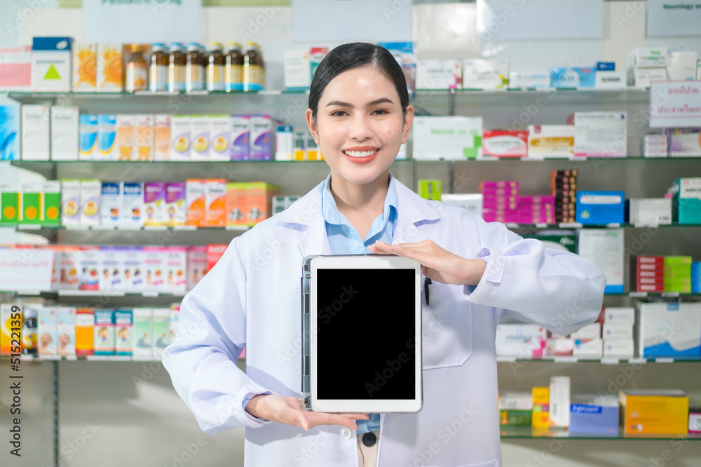 Portrait of female pharmacist using tablet in a modern pharmacy drugstore.