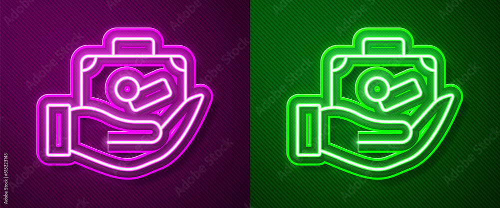 Obraz premium Glowing neon line Travel suitcase in hand icon isolated on purple and green background. Traveling baggage insurance. Security, safety, protection, protect concept. Vector