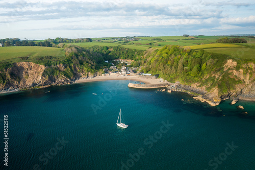 Aerial view of Yacht anchored in Polkerris harbour with view of harbour, beach and surrounding countryside, Par, Polkerris, Cornwall, United Kingdom. photo