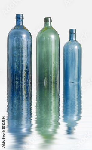 Photo Three glass bottles on white surface with water effect