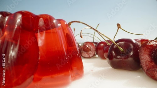 Red jelly with cherries, I tap the jelly with a spoon and it shakes, close-up. photo