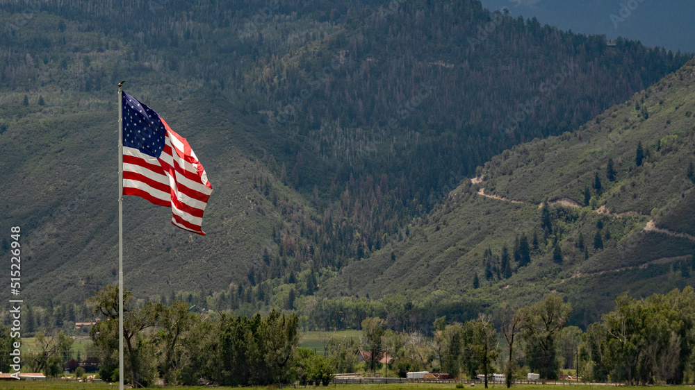 American flag majestically flying over a pasture high in the San Jaun Mountains of Colorado; concepts of American and patriotism
