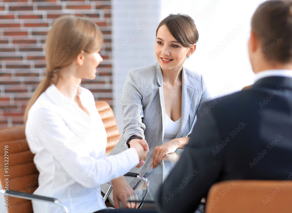 handshake of a Manager, and a client sitting behind a Desk
