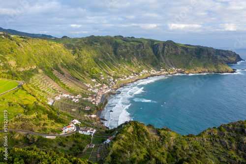 Aerial view of houses along the coastline with terrace fields on the slopes of the cliff overlooking the ocean, Santo Espirito, Azores, Portugal. photo