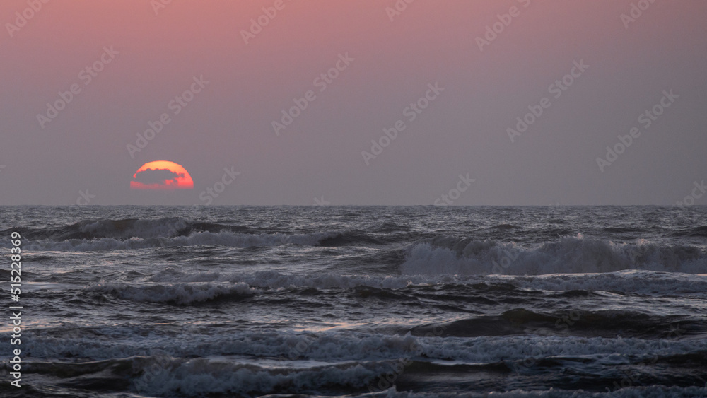 Sunrise over the beach in coastal Texas; clouds in front of the sun Sunrise over the beach in coastal Texas; clouds in front of the sun