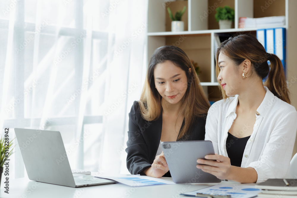 Atmosphere in the office of a startup company, two female employees are discussing, brainstorming ideas to working on summaries and marketing plans to increase sales and prepare reports to managers. Atmosphere in the office of a startup company, two female employees are discussing, brainstorming ideas to working on summaries and marketing plans to increase sales and prepare reports to managers.