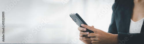 young businesswoman looking at financial information from a mobile phone, she is checking company financial documents, she is a female executive of a startup company. Concept of financial management.