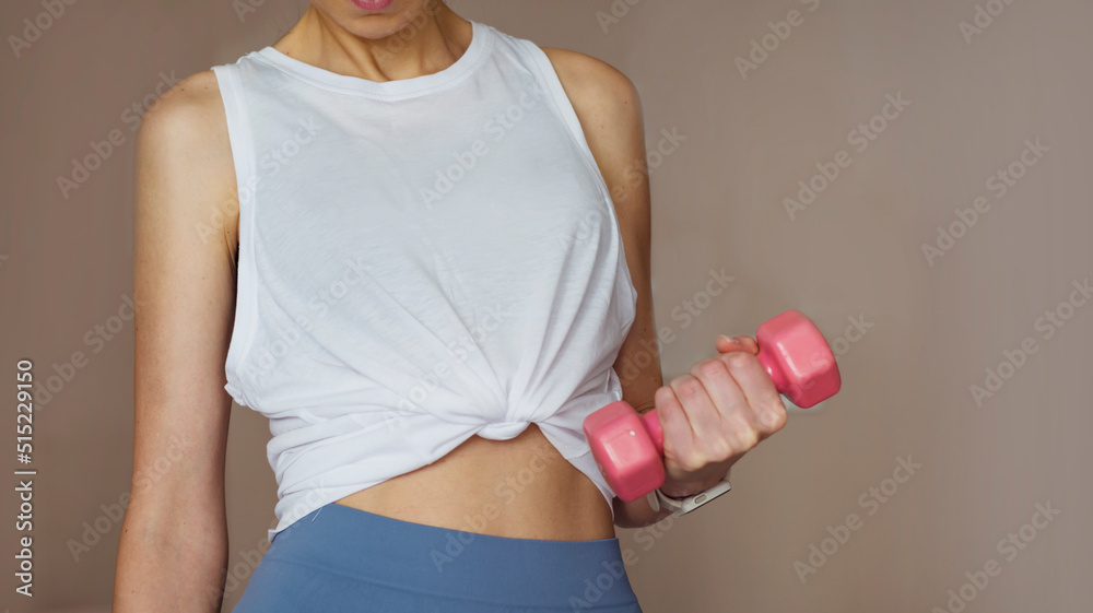 Woman with leggings holding pink dumbbell .Fitness And Healthy Lifestyle Concept Woman with leggings holding pink dumbbell .Fitness And Healthy Lifestyle Concept