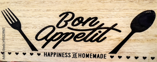 Fotografia Bon Appetit sign with fork and spoon on wooden background
