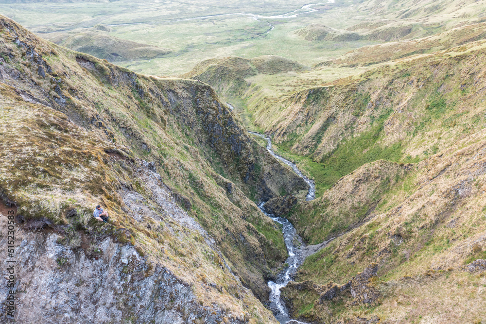 Aerial view of a river streaming along the valley near Captains Bay on Unalaska island, Alaska, United States. Aerial view of a river streaming along the valley near Captains Bay on Unalaska island, Alaska, United States.
