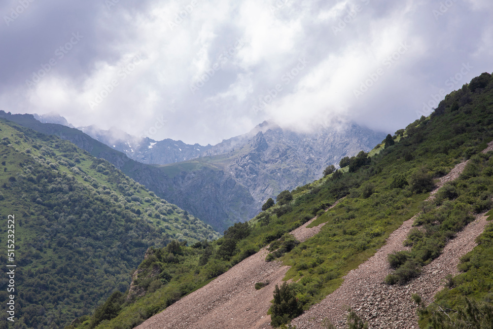 View of the Tian Shan Mountains with storm clouds, in Kyrgyzstan. View of the Tian Shan Mountains with storm clouds, in Kyrgyzstan.
