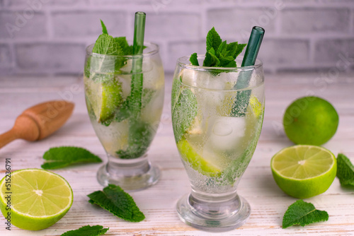 Cold mojito with lime and mint in glasses.