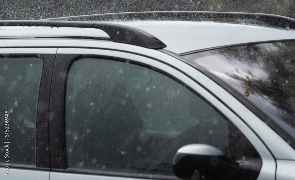 Car in the rain. Close-up of raindrops falling on a passenger car.