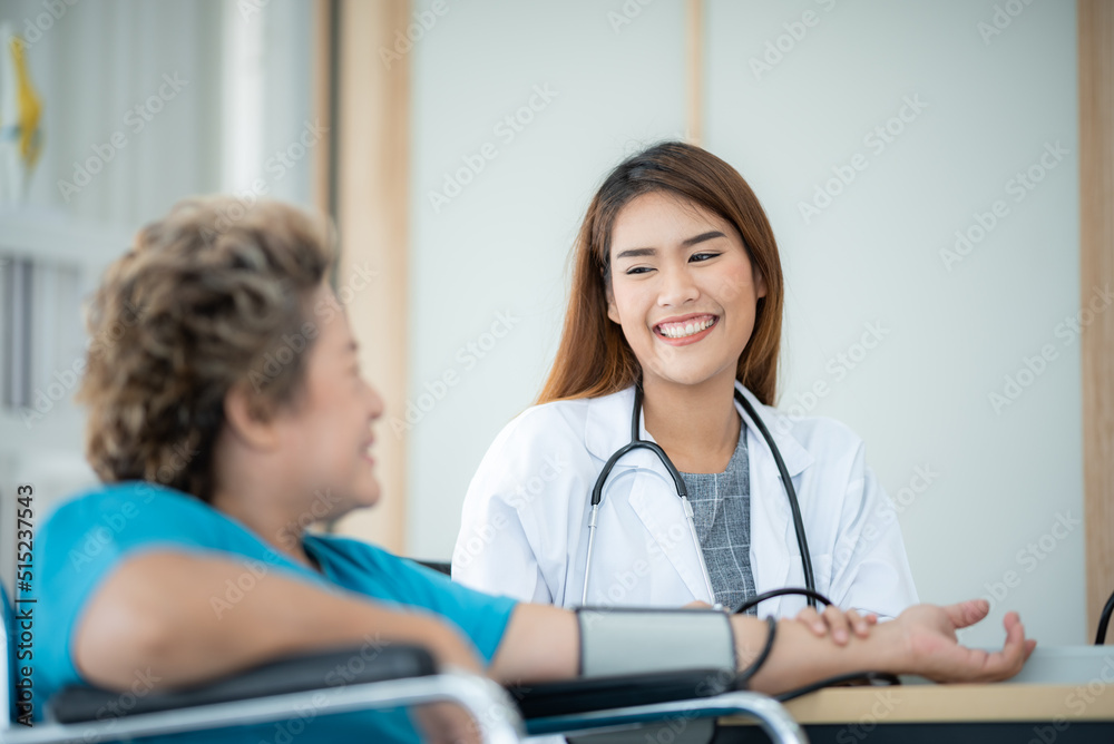 Smiling young female doctor checking and measuring blood pressure of senior patient Smiling young female doctor checking and measuring blood pressure of senior patient
