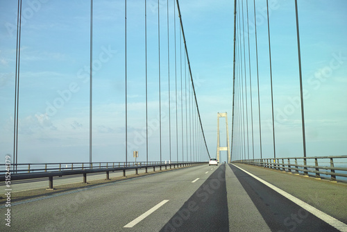 Storebaelt suspension bridge in Denmark against blue sky background. Overpass road crossing for transport to link travel destination routes. Infrastructure and architecture design of famous landmark
