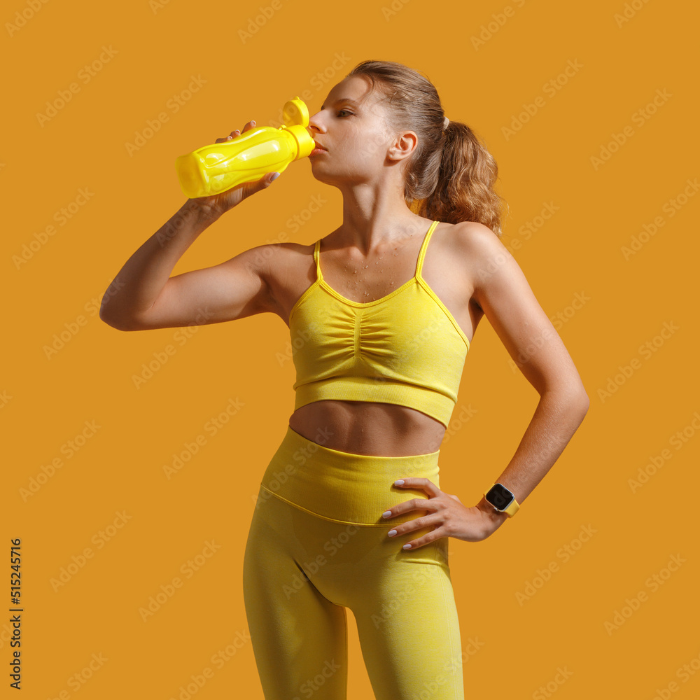 a young attractive girl in yellow sportswear. Fitness. the concept of a healthy lifestyle and sports. yellow background a young attractive girl in yellow sportswear. Fitness. the concept of a healthy lifestyle and sports. yellow background