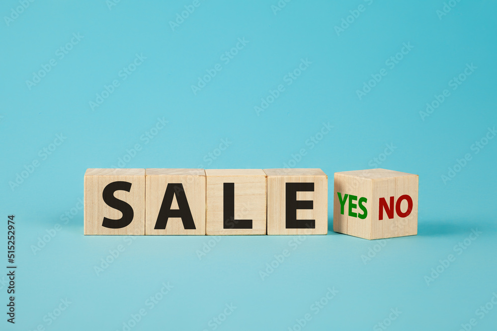 Sale word no to yes. Hand turns a dice and changes the word no to yes. On sale Cubes dice with Sale Yes or No on wooden background Sale word no to yes. Hand turns a dice and changes the word no to yes. On sale Cubes dice with Sale Yes or No on wooden background
