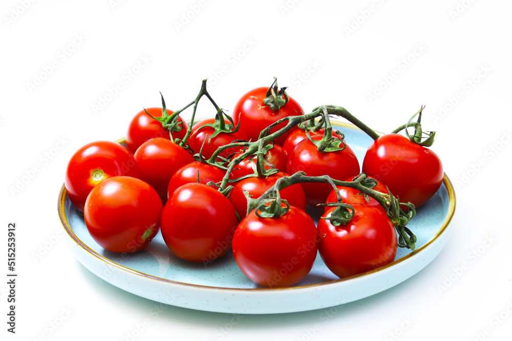 Cherry tomatoes in a blue plate on a white background. Shallow depth of field Cherry tomatoes in a blue plate on a white background. Shallow depth of field