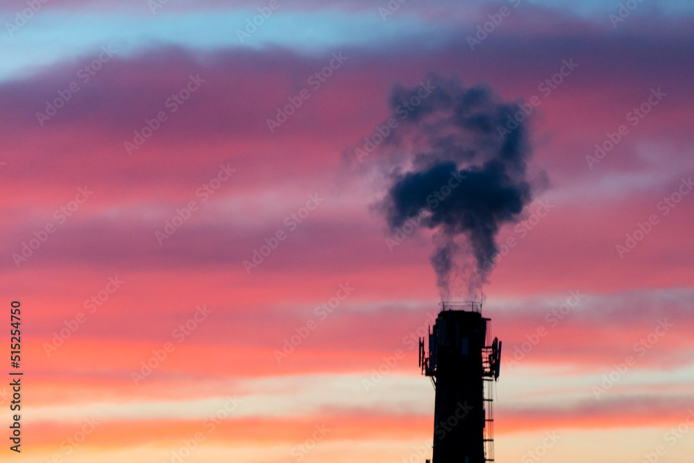 Factory smoking pipe, emissions of smoke into the atmosphere of the city. Evening sky