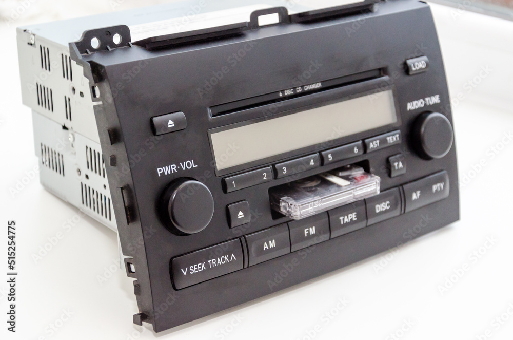 Old car audio CD and cassette player 2 DIN. On a lite background Old car audio CD and cassette player 2 DIN. On a lite background