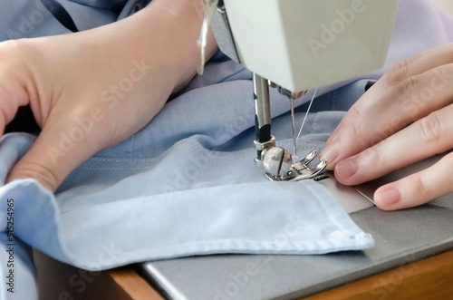 Sewing striped shirt on a sewing machine. Сlose up