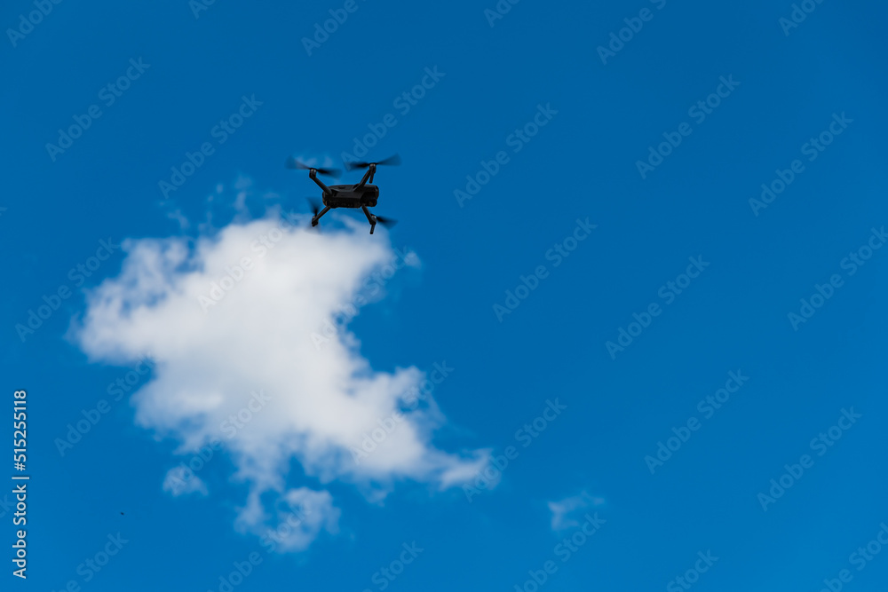 Small drone flying at sky around small cloud Small drone flying at sky around small cloud