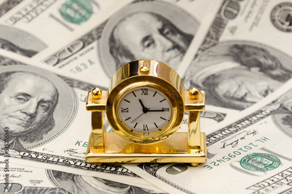 Time is money. Gold watch on 100 dollar bills. The concept of the transience of time Time is money. Gold watch on 100 dollar bills. The concept of the transience of time