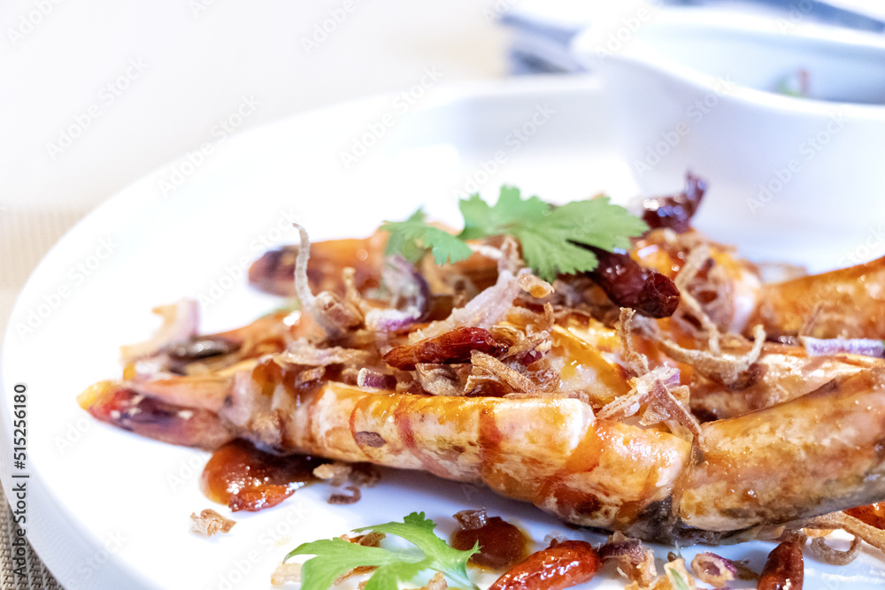 close up of Thai food prawns with tamarind sauce and green leaves of coriander for decoration. close up of Thai food prawns with tamarind sauce and green leaves of coriander for decoration.