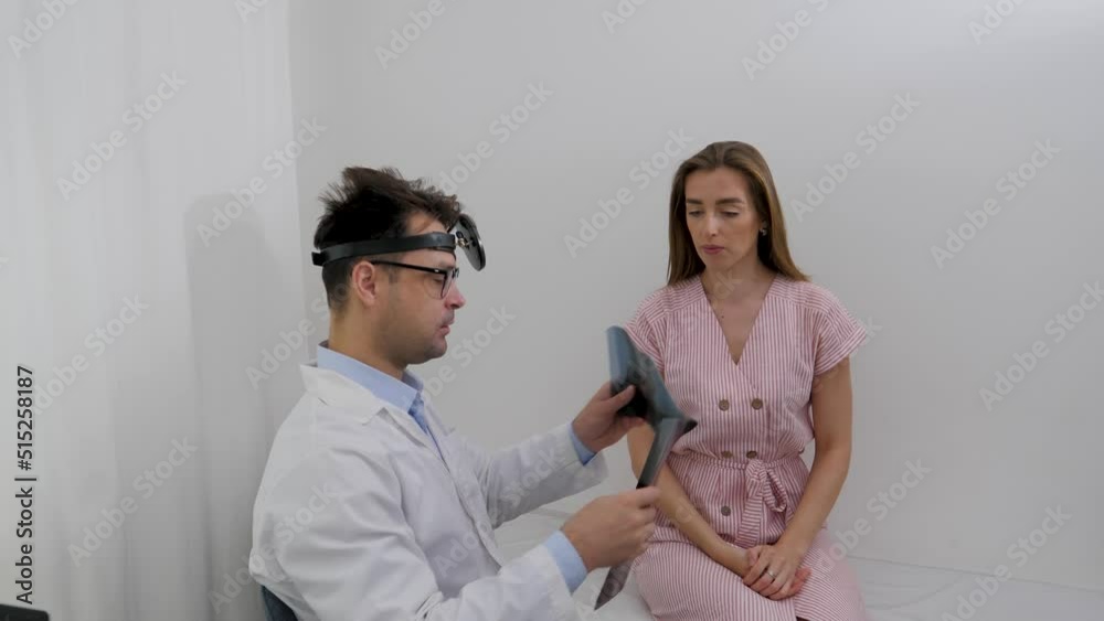 the doctor shows the x-ray to the girl patient and talks about the further course of treatment the doctor shows the x-ray to the girl patient and talks about the further course of treatment