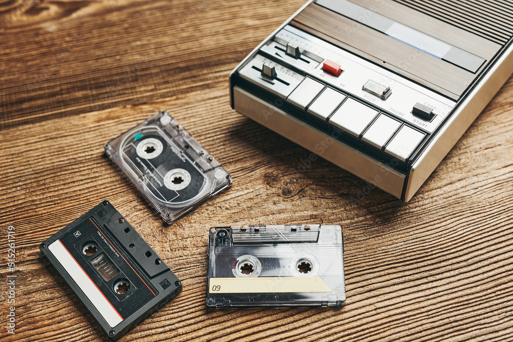 Compact cassette tapes and cassette recorder. Retro music style. 80s music party. Vintage style. Analog equipment. Stereo sound. Back to the past Compact cassette tapes and cassette recorder. Retro music style. 80s music party. Vintage style. Analog equipment. Stereo sound. Back to the past
