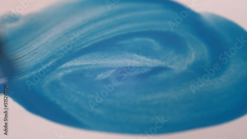 Artist brush painting on wet paper. 4K macro close up. Watercolor painting. Blue color on textured paper. Brush strokes.