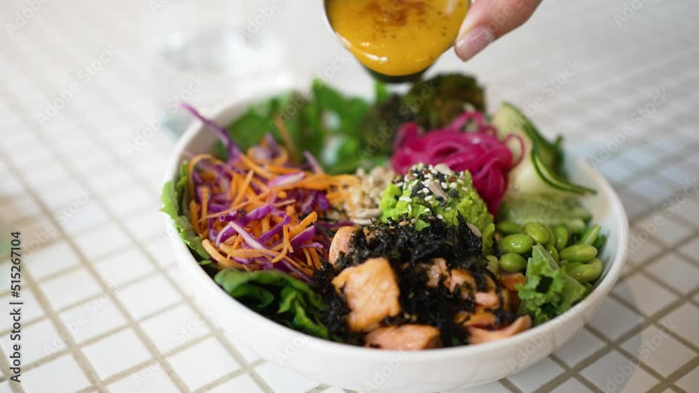 Woman pours sauce on delicious vegetarian meal with fresh salad and seafood in white bowl. Housewife enjoys homemade dinner closeup slow motion Woman pours sauce on delicious vegetarian meal with fresh salad and seafood in white bowl. Housewife enjoys homemade dinner closeup slow motion