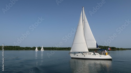 Nautisme sur le lac du Der Chantecoq, en Champagne Ardenne, dans la région Grand Est, avec un voilier blanc naviguant sur l’eau bleue du lac (France)