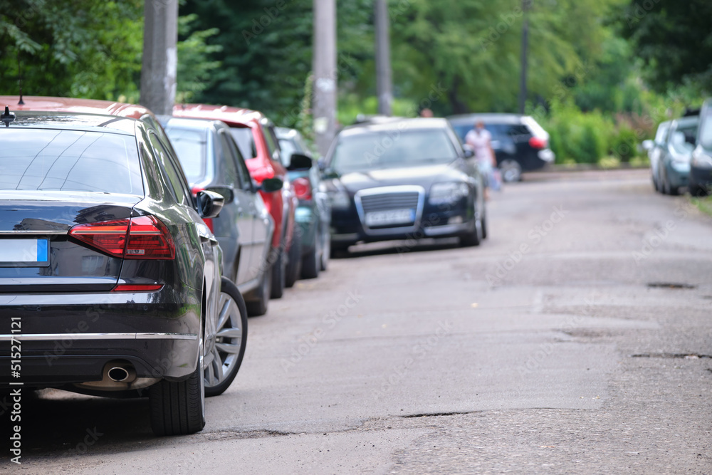 Cars parked in line on city street side. Urban traffic concept